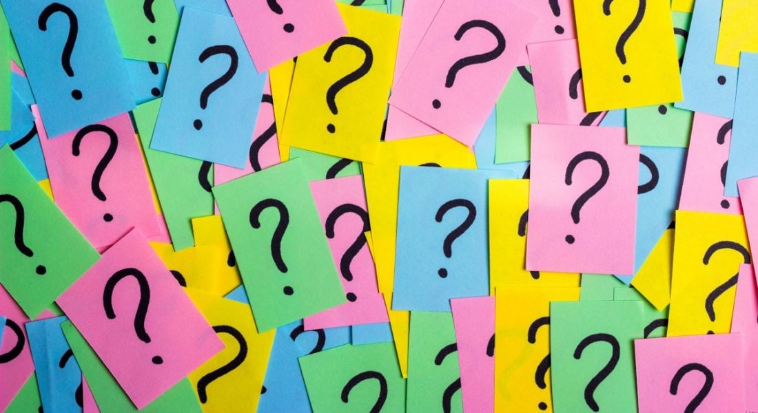 Lots of brightly coloured memo notes with black inked question marks on them.