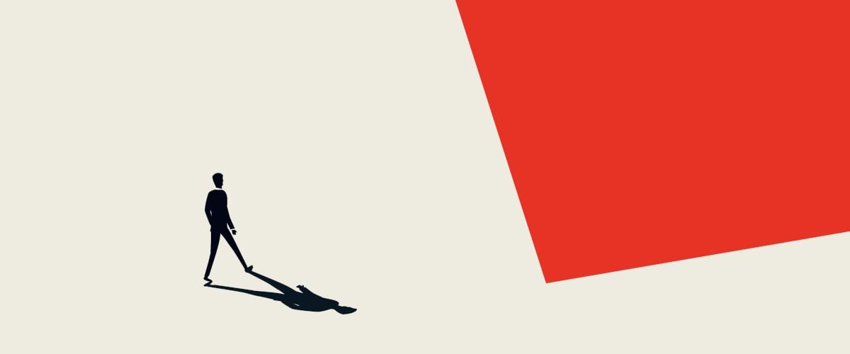 A silhouette of an individual with its shadow in view on a beige and red abstract-shaped background.