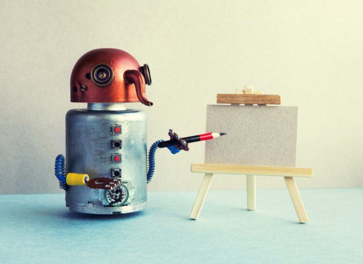 A robot using a pencil to draw on a piece of paper. Used to represent the concept of AI-generated art.