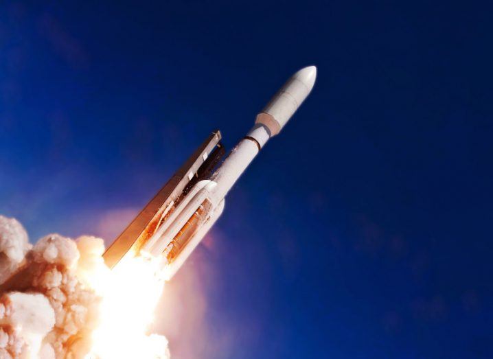 A space rocket blasting off into space, with jets of fire and clouds of smoke under the rocket.