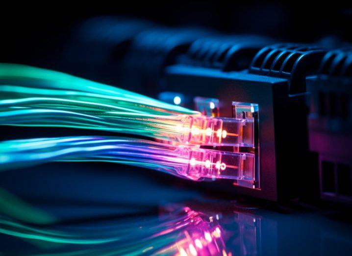 Different coloured fibre optic cables plugged into the back of a router. Used to represent broadband.