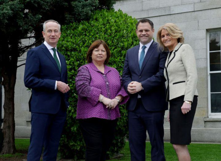 Two women and two men stand outside and smile at the camera.