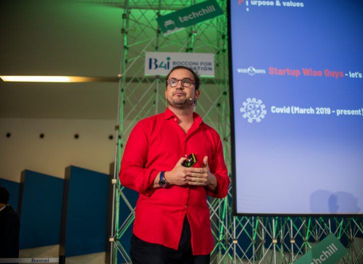 Cristobal Alonso of Startup Wise Guys stands speaking on a stage.