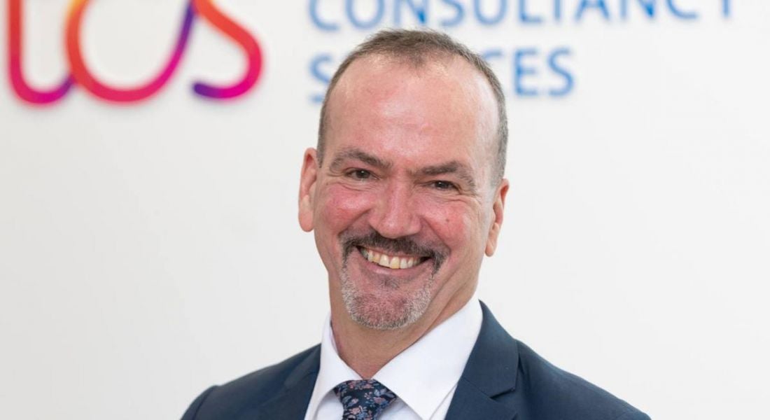A TCS headshot of Tim Kelley with the TCS branding behind him.