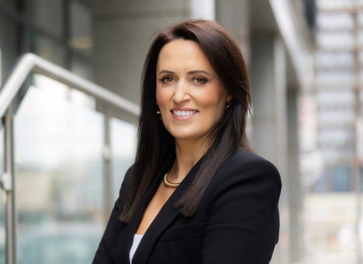 A woman stands smiling at the camera wearing a black suit jacket. She is Gillian Whelan, managing director at Aspira.