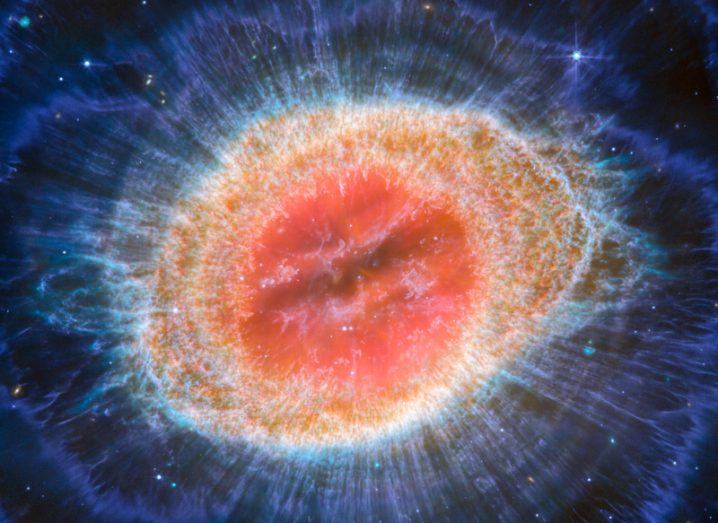 A colourful image of a nebula in space. It is an intense red and orange colour.